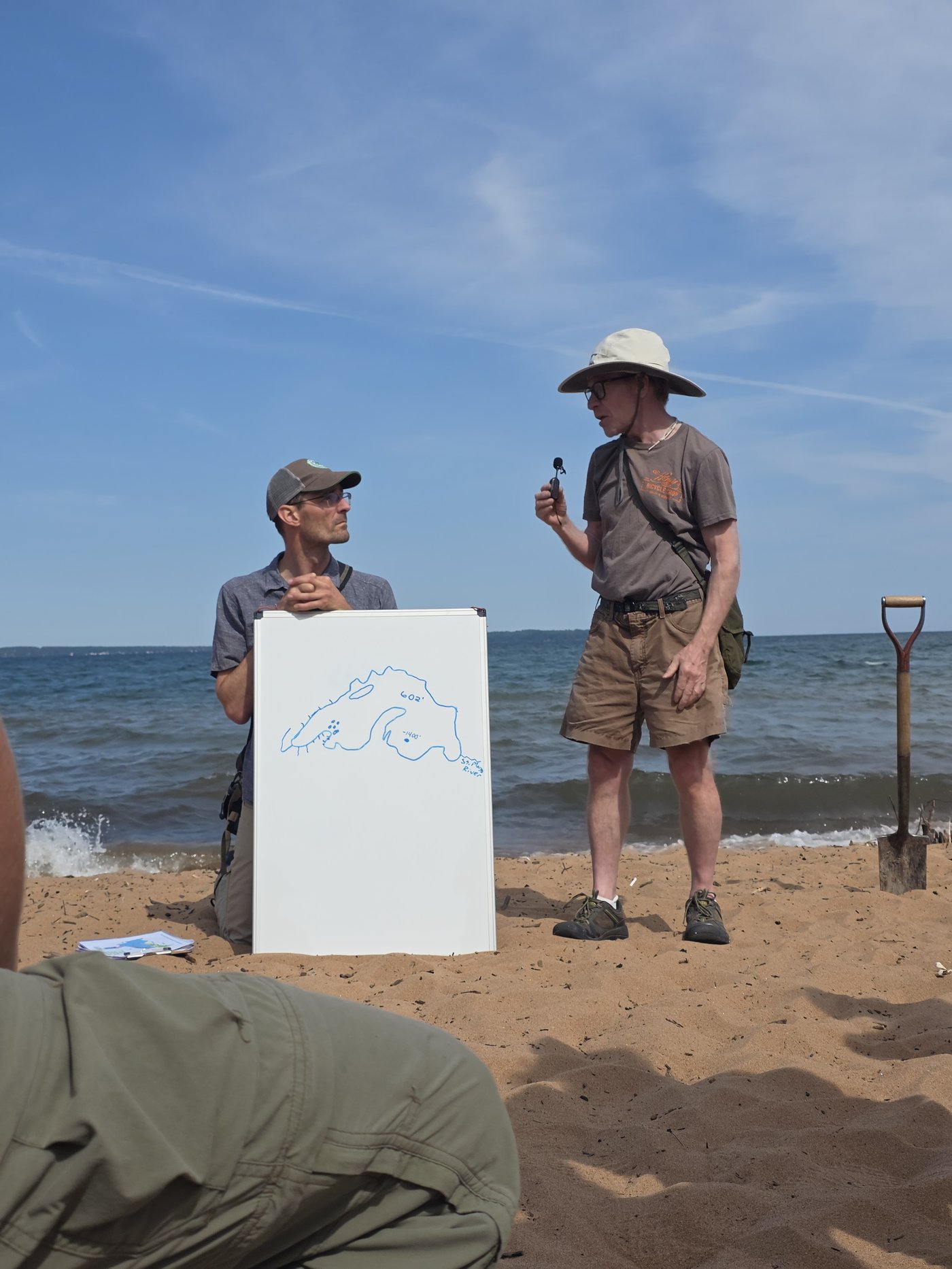 Tom Fitz and Dave Ullman leading a geology session on the beach, with a whiteboard sketch of the Lake Superior Basin