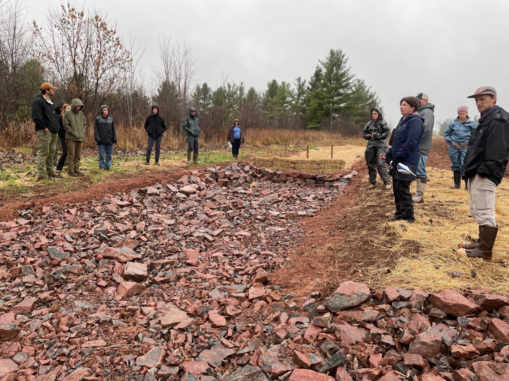 Symposium participants gathered around a newly constructed rock channel feature at Berweger Farm during the 2024 Act 157 field tour