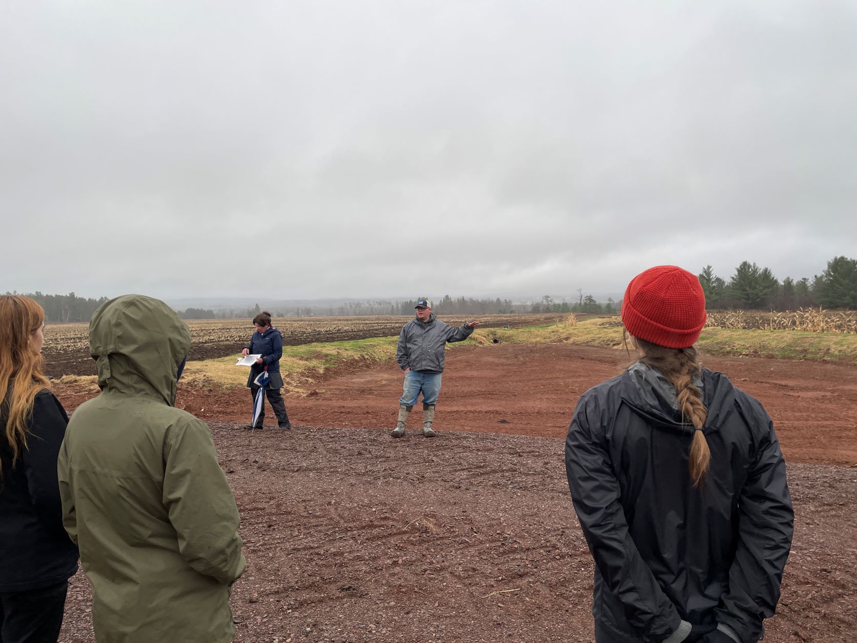 A landowner explaining the Fischbach Wetland restoration project to symposium field tour participants on a rainy October day in Ashland County